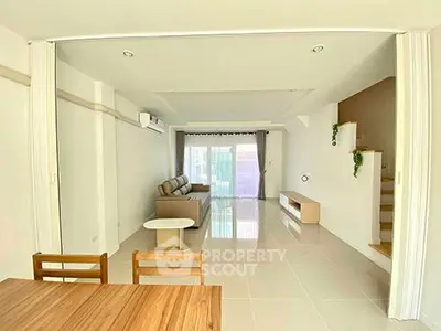 Spacious modern living room with sleek tile flooring and natural light