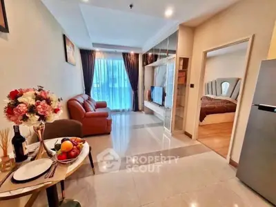 Modern open-plan living room with cozy seating and elegant dining area, leading to a stylish bedroom.