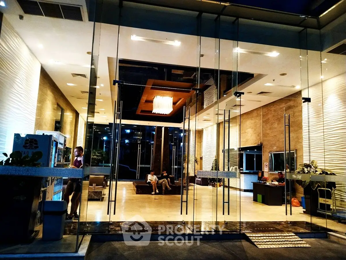 Luxurious building entrance with modern glass facade and elegant interior design.
