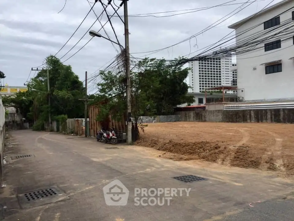 Vacant land plot in urban area ready for development, surrounded by buildings and infrastructure.