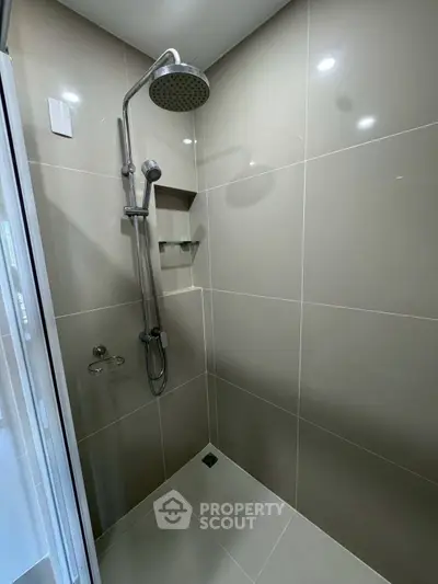 Modern bathroom shower with sleek tiles and rainfall showerhead in contemporary home.