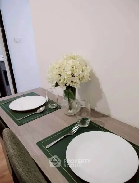 Elegant dining setup with floral centerpiece in modern apartment