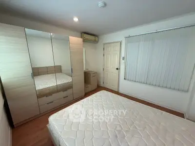 Spacious bedroom with large wardrobe and comfortable bed in modern apartment.