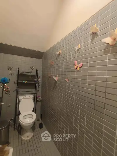 Charming bathroom with butterfly decor and modern tiled walls