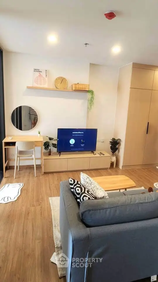 Modern living room with stylish decor, wooden flooring, and cozy seating area.