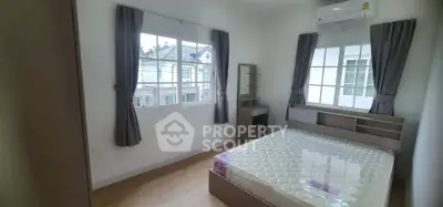 Bright and airy bedroom with large windows and modern furnishings in a stylish home.