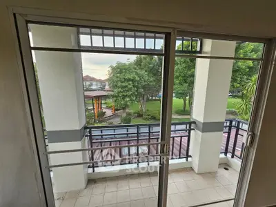 Spacious balcony with serene garden view in modern apartment