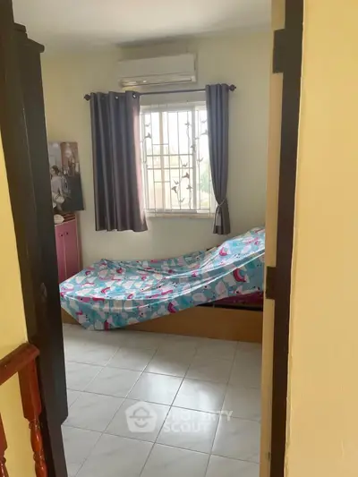 Cozy bedroom with air conditioning and natural light, perfect for relaxation.