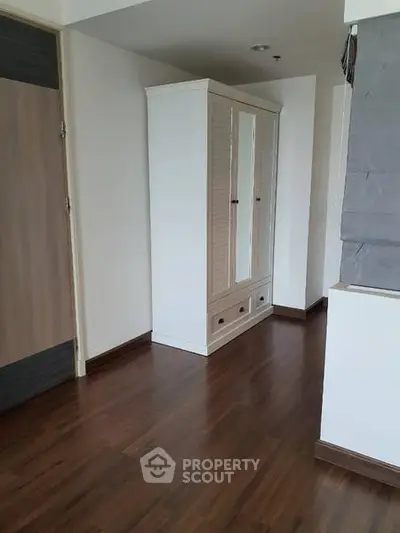 Spacious interior with wooden flooring and a stylish wardrobe, perfect for modern living.