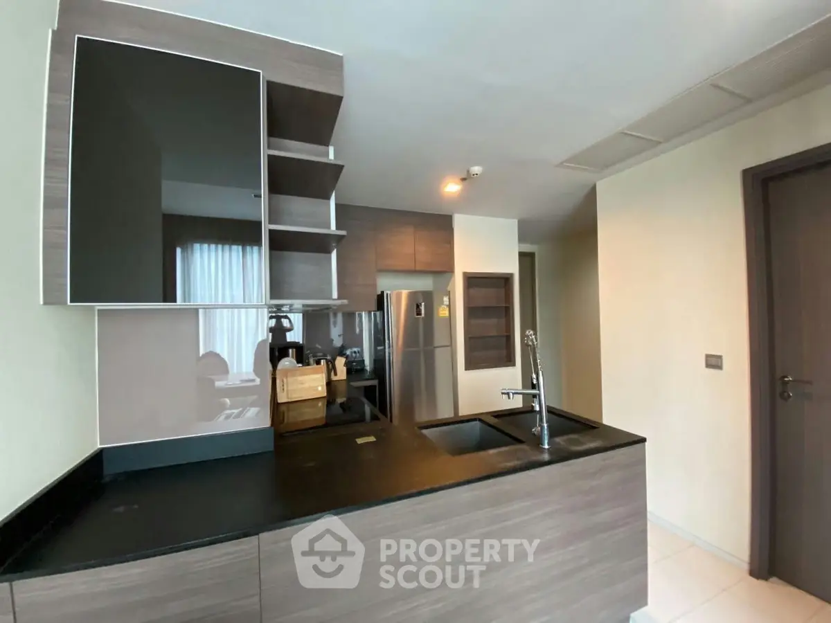 Modern kitchen with sleek design and stainless steel appliances in a stylish apartment.