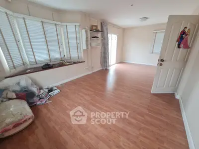 Spacious empty living room with wooden flooring and large windows