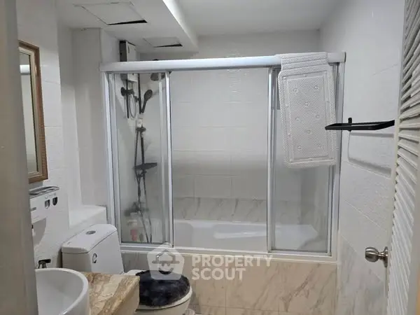 Modern bathroom with glass shower doors and marble accents
