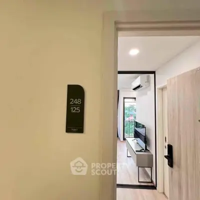 Modern apartment entrance with sleek interior and wall-mounted TV