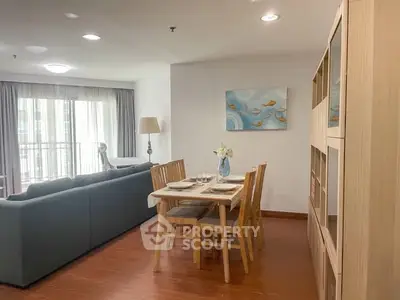 Spacious living room with dining area and large windows in modern apartment.