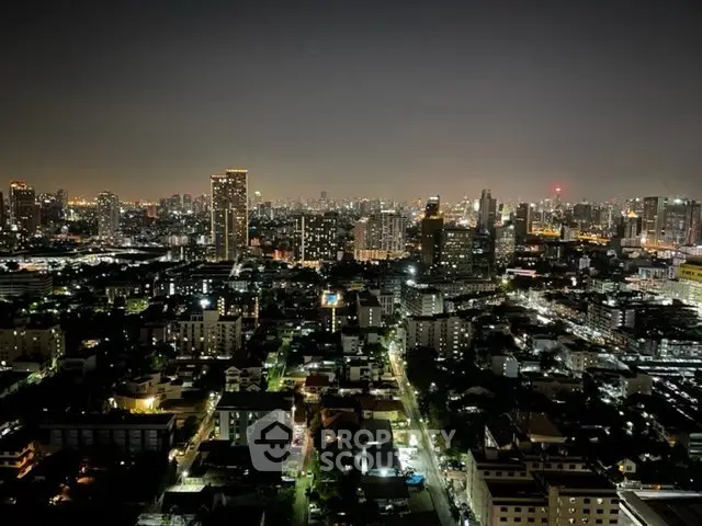 Stunning cityscape view from a high-rise building at night, showcasing vibrant urban lights and skyline.