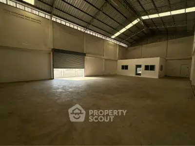 Spacious industrial warehouse with high ceilings and ample natural light.