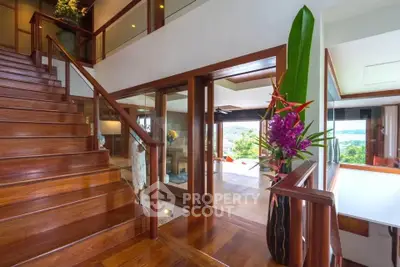 Luxurious wooden staircase leading to a spacious living area with stunning views.
