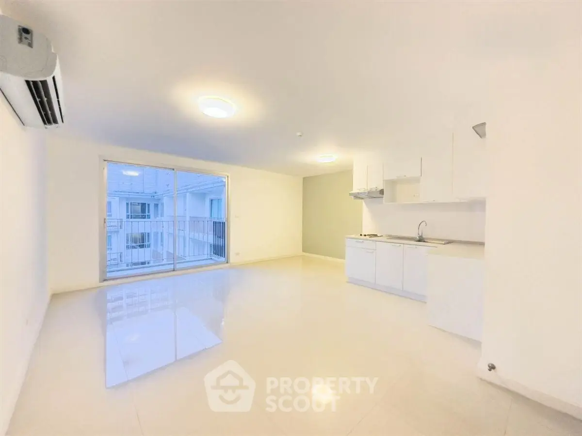 Spacious modern living room with open kitchen and large window view