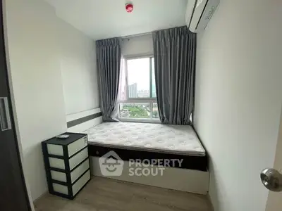 Cozy bedroom with city view, featuring a comfortable bed and modern decor.