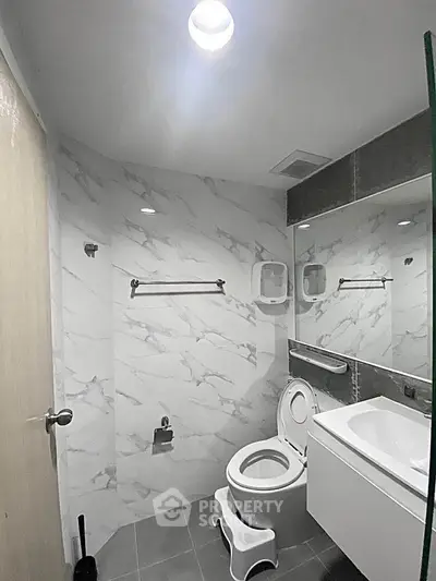Modern bathroom with marble walls and sleek fixtures in a contemporary home.