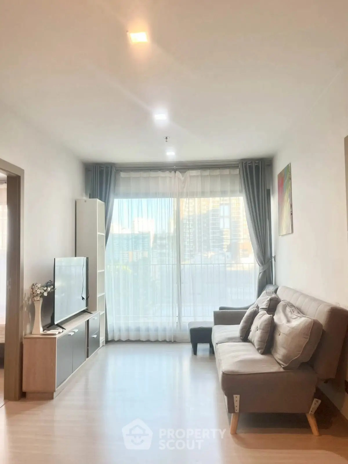 Modern living room with large window and stylish furniture in a bright apartment.