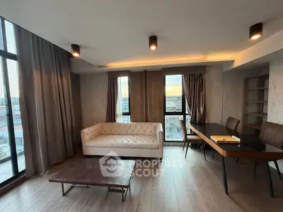 Spacious modern living room with elegant furniture and large windows offering city views.