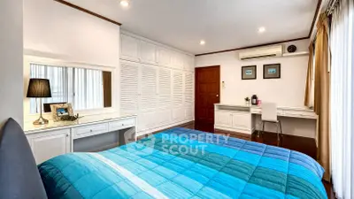 Spacious bedroom with modern decor and ample storage in a stylish home.