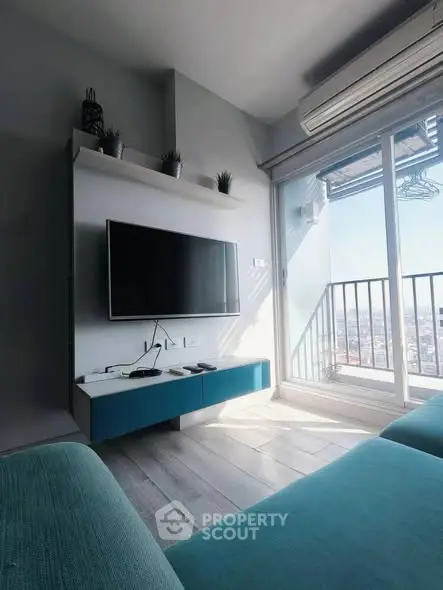Modern living room with balcony and city view, featuring sleek furniture and natural light.