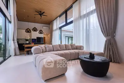 Luxurious modern living room with high ceilings, elegant sofa, and large windows offering natural light.
