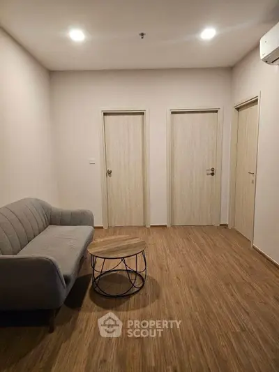 Cozy minimalist living room with wooden flooring and modern furniture.