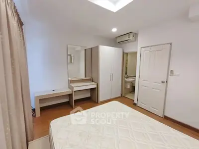 Spacious bedroom with modern furniture and ensuite bathroom in a stylish apartment.