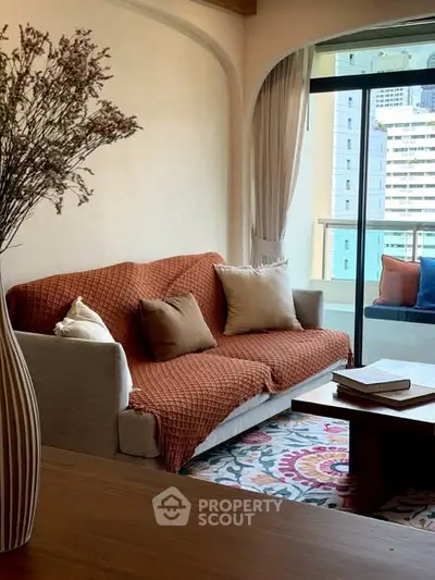 Charming living room with cozy sofa and vibrant decor, featuring a city view balcony.