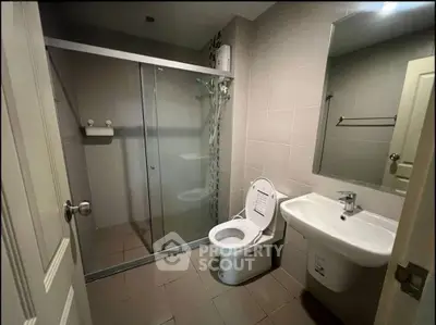 Modern bathroom with glass shower enclosure and sleek fixtures in a contemporary home.