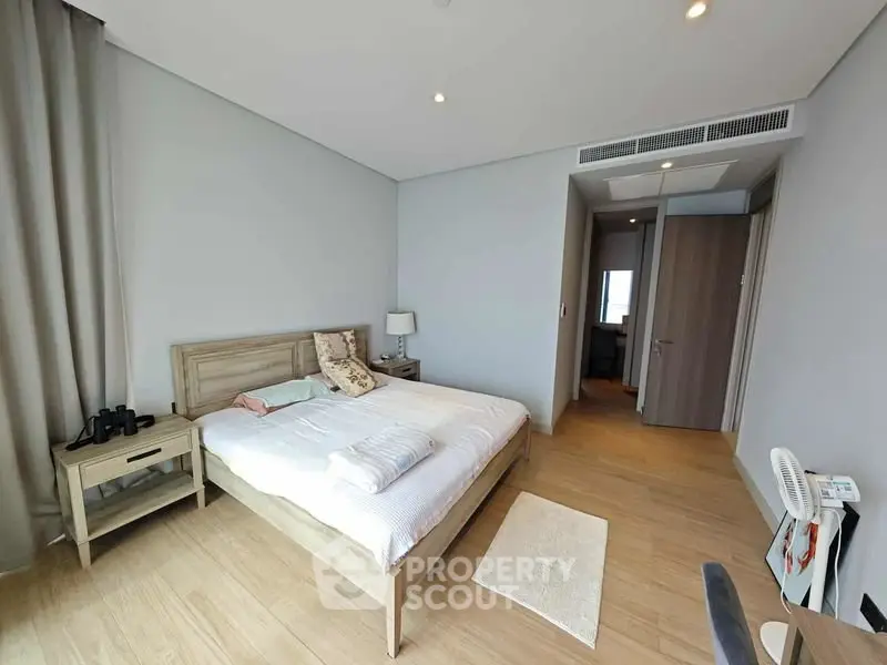 Spacious modern bedroom with wooden flooring and elegant decor