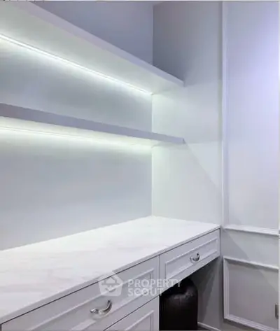 Elegant study room with sleek white shelves and marble desk, perfect for productivity.