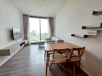 Modern living room with large window and stylish furniture in a high-rise apartment.