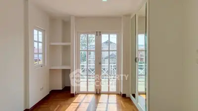 Bright bedroom with large windows and mirrored closet doors