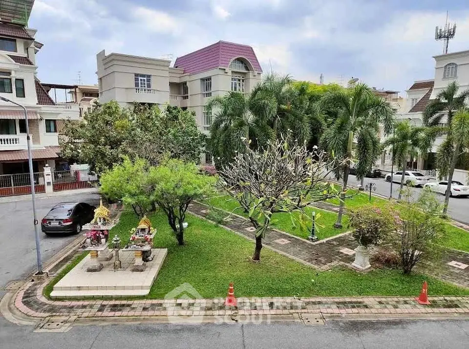 Charming residential neighborhood with lush green garden and elegant architecture.