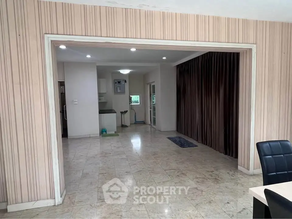 Spacious open-plan living area with marble flooring and modern kitchen.