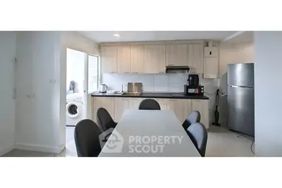 Modern kitchen with dining area and appliances in a sleek open layout.