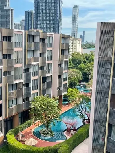 Modern residential complex with pool and lush greenery, offering urban living with scenic views.