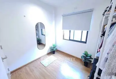 Bright minimalist room with wooden flooring and mirror, ideal for storage or small office.