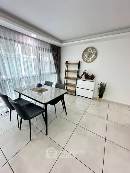 Modern dining area with elegant table and chairs, large windows, and stylish decor.