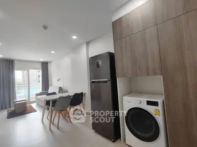 Modern apartment interior with open layout, featuring a sleek kitchen and cozy living area.