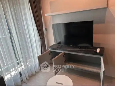 Modern living room with sleek TV stand and large window with elegant curtains.
