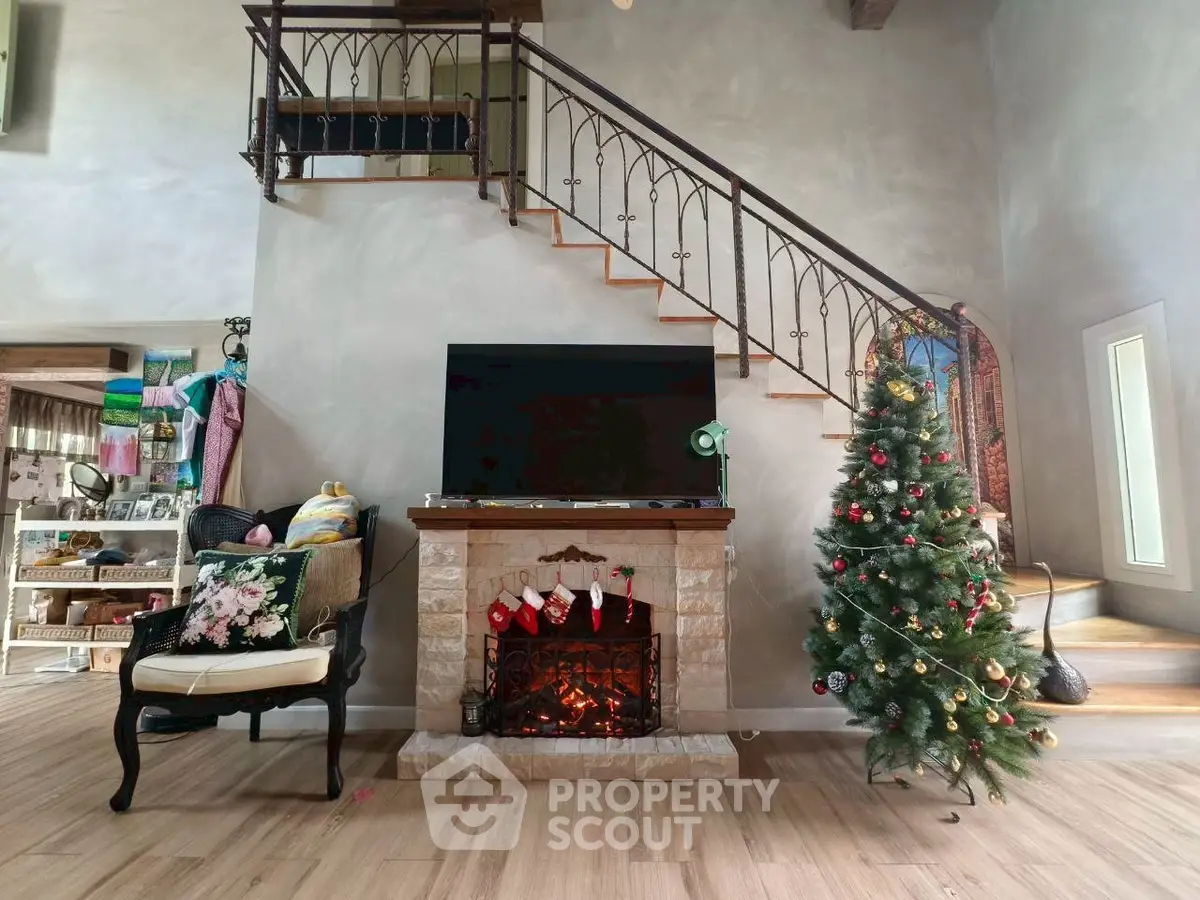 Charming living room with cozy fireplace and festive decor, featuring a stylish staircase and elegant flooring.