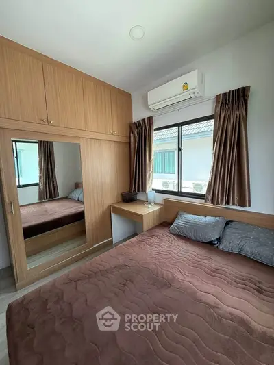Cozy bedroom with built-in wardrobe and air conditioning, perfect for relaxation.