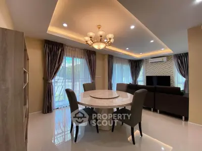 Elegant living room with modern chandelier and stylish furniture, featuring large windows and a cozy ambiance.