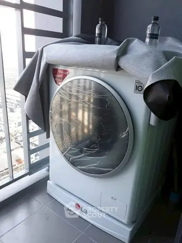 Modern washing machine on a balcony with city view, perfect for urban living convenience.