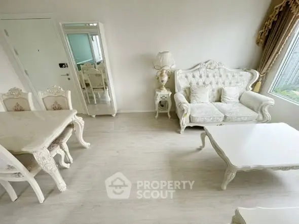 Elegant living room with classic white furniture and large window for natural light.